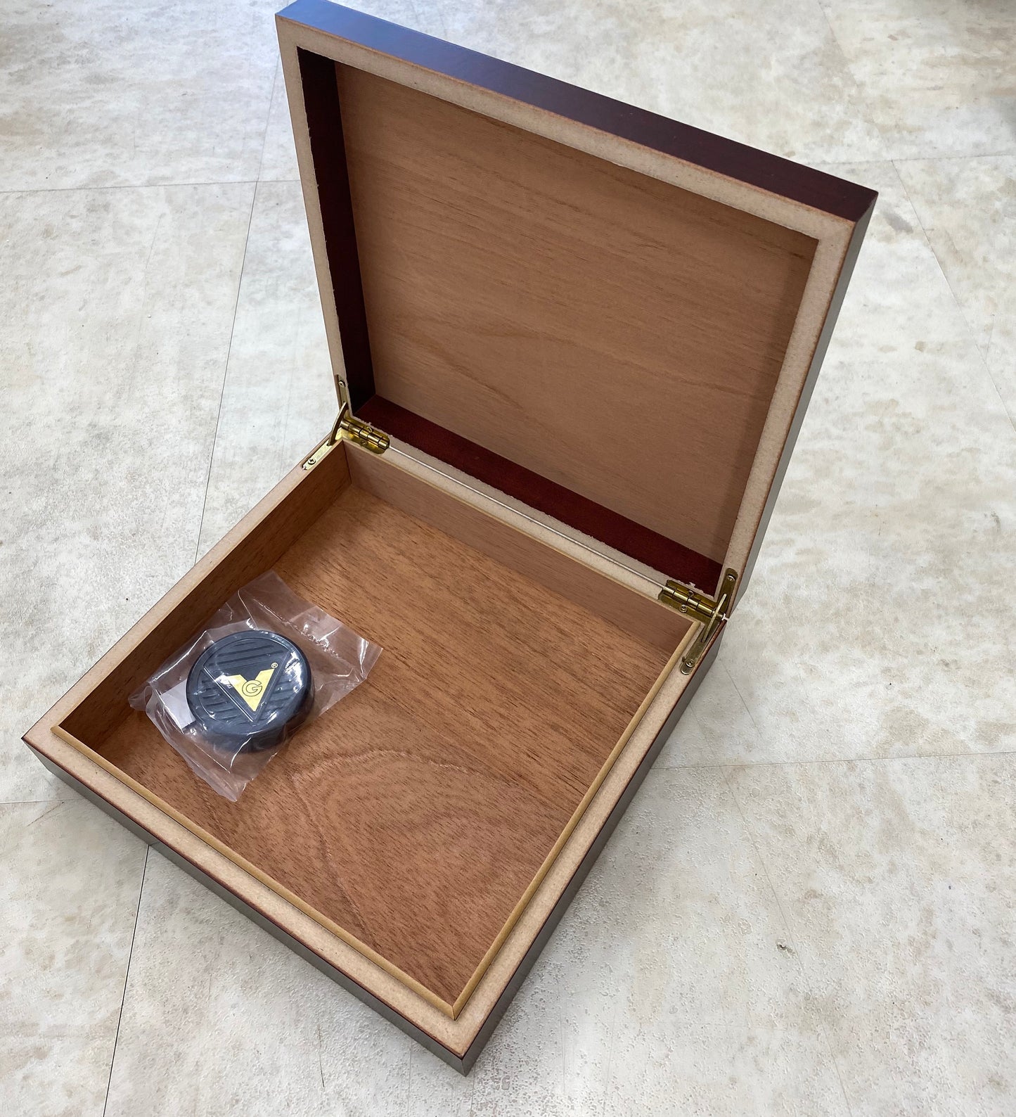 A custom-designed wood cigar box packaged and ready as a personalized groomsmen gift.