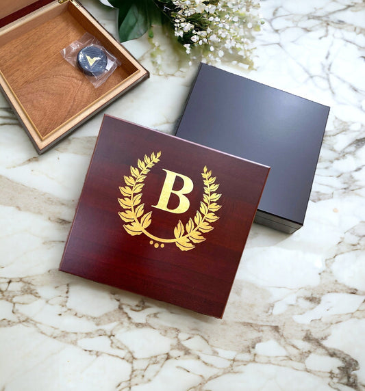 Personalized desktop humidor showing a custom name engraved in gold on black wood finish.
