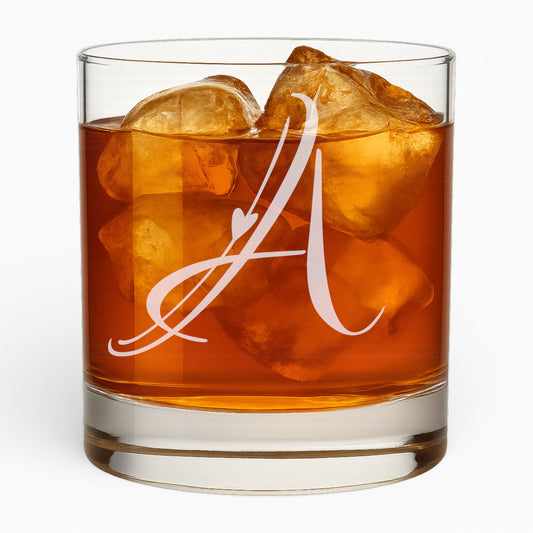Whiskey glass with a flowing script letter A and a small heart, filled with whiskey and ice.