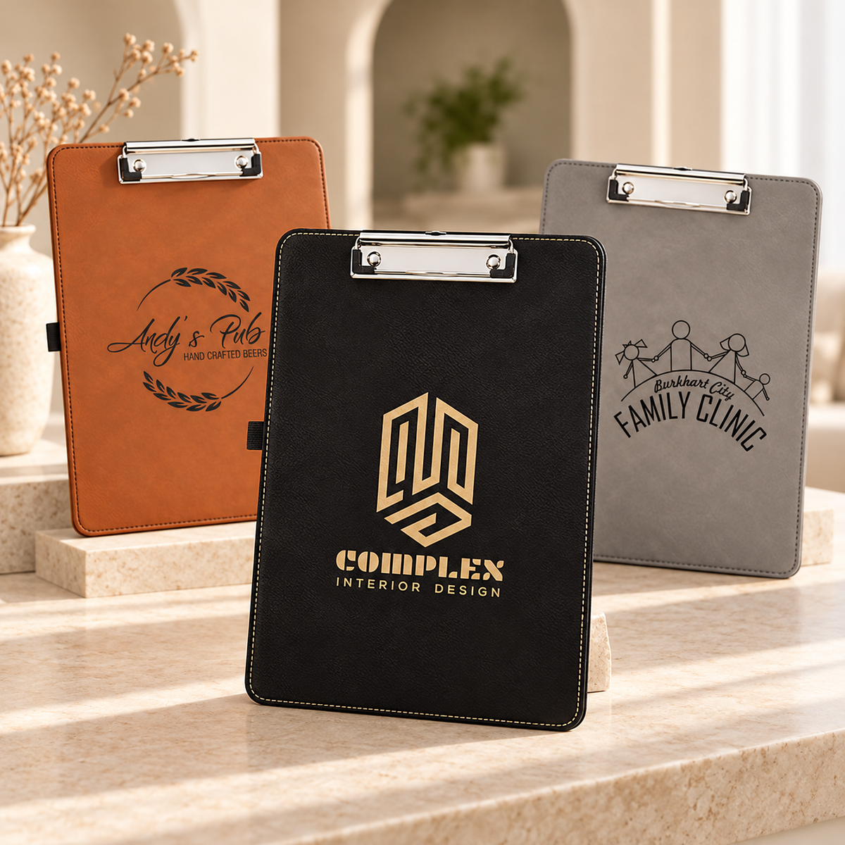 Personalized engraved leatherette clipboards in rawhide, black and gold, and gray with custom logos for a business and a family clinic, gift for teachers, nurses and office staff