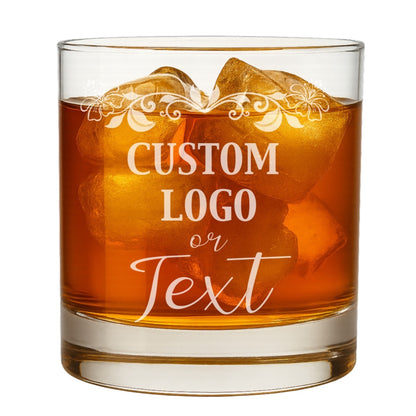 Clear custom logo whiskey glass with an etched corporate brand, sitting on a wooden surface.