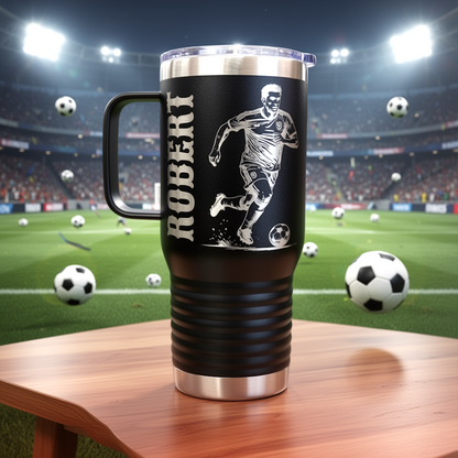 Black travel mug with soccer player design and 'ROBERT' text on a table with soccer balls, stadium background