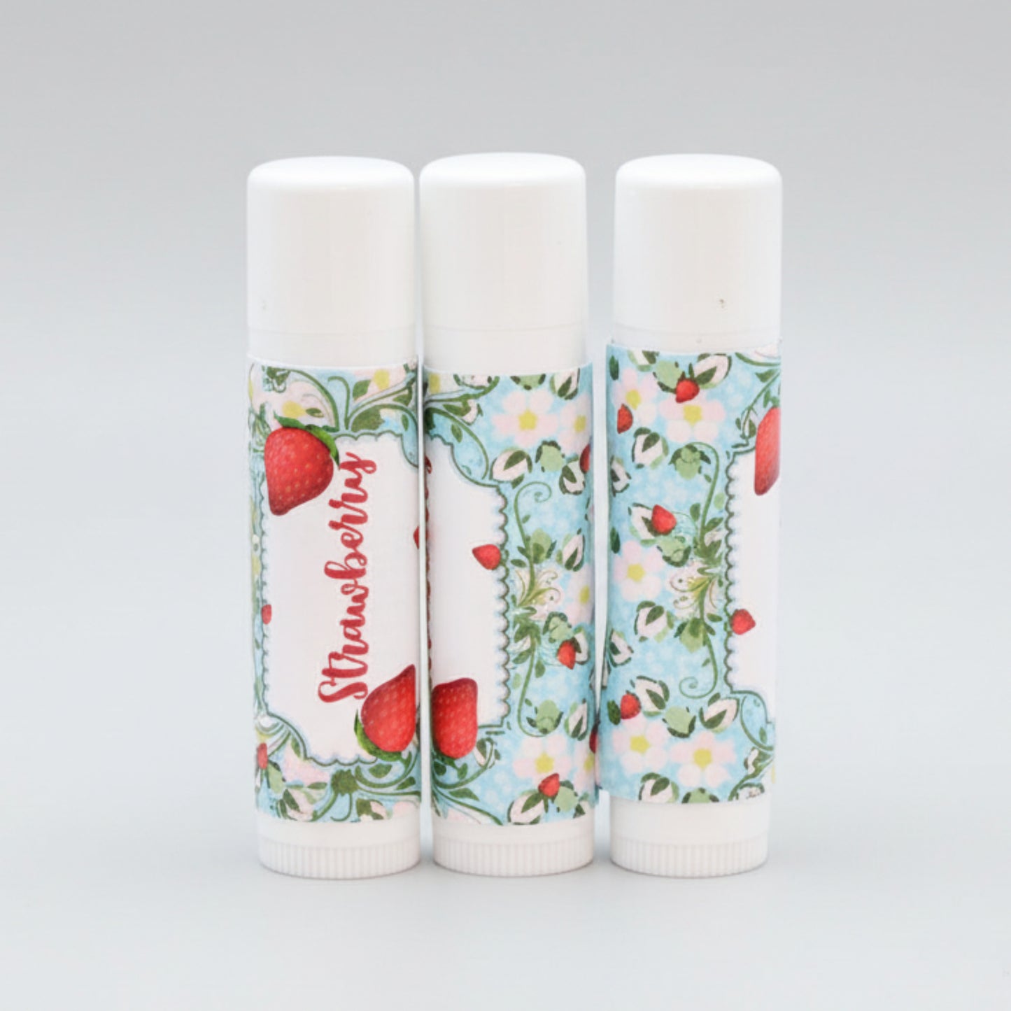 Strawberry lip balm labels with bright berry artwork, shown as round stickers for standard 0.15 oz tubes.