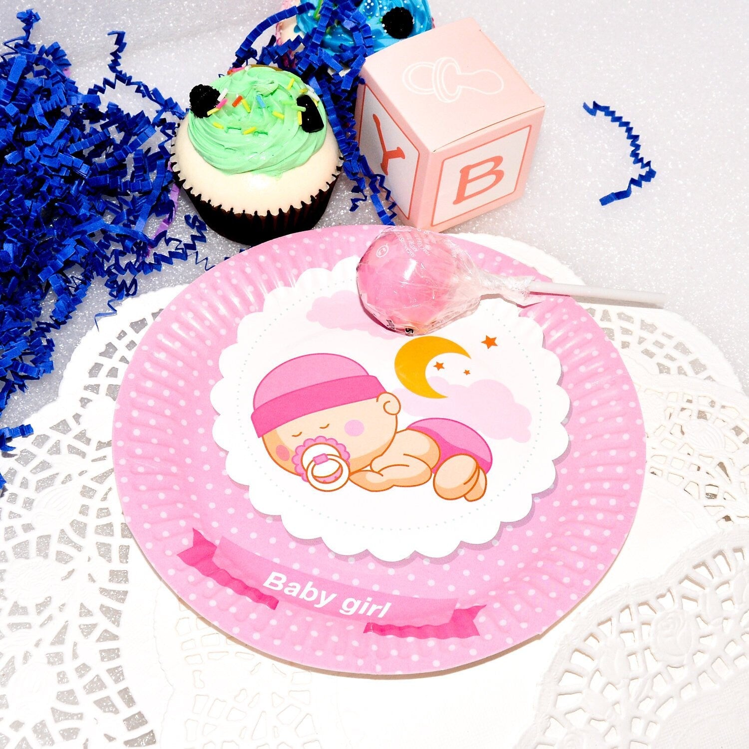Overhead shot of multiple pink baby shower dessert plates arranged on a table, ready for sweet treats at a celebration.