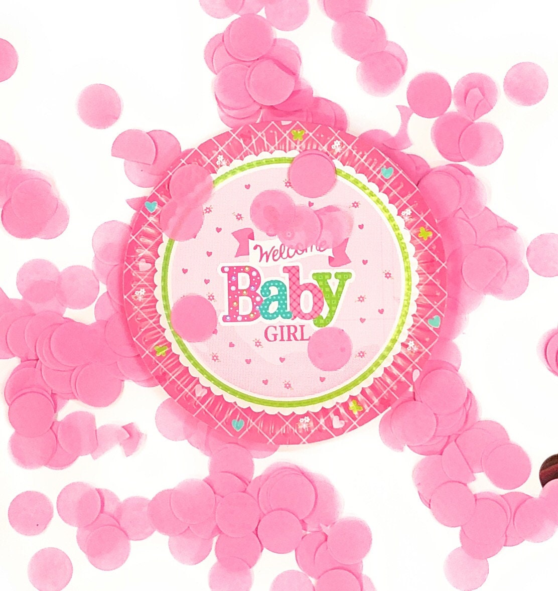 Overhead shot of a 'Welcome Baby Girl' paper plate next to a slice of cake, illustrating its 7-inch size for desserts.