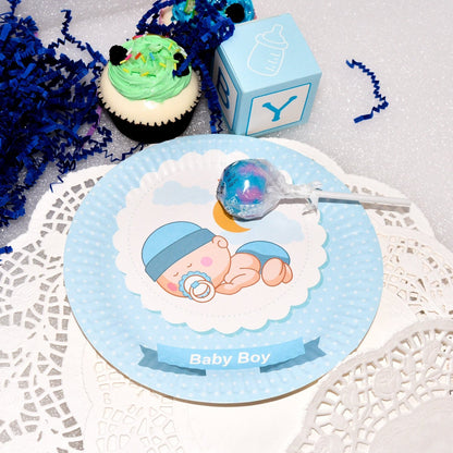 A stack of blue sleeping baby boy dessert plates next to party treats, setting the scene for a celebration.