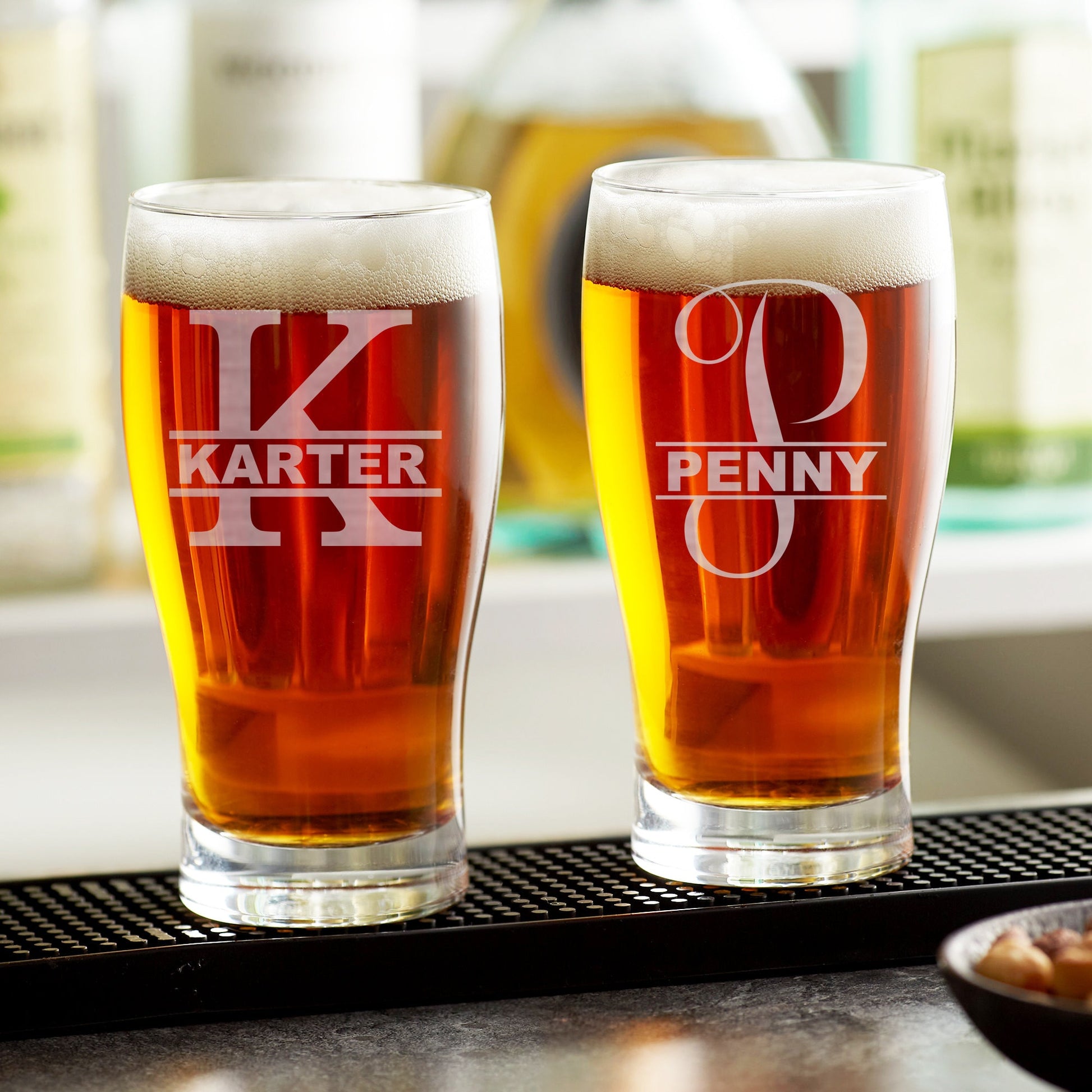 A single custom etched beer glass from an angle, highlighting the permanent monogram and the glass's texture.