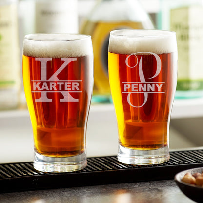 A single custom etched beer glass from an angle, highlighting the permanent monogram and the glass's texture.
