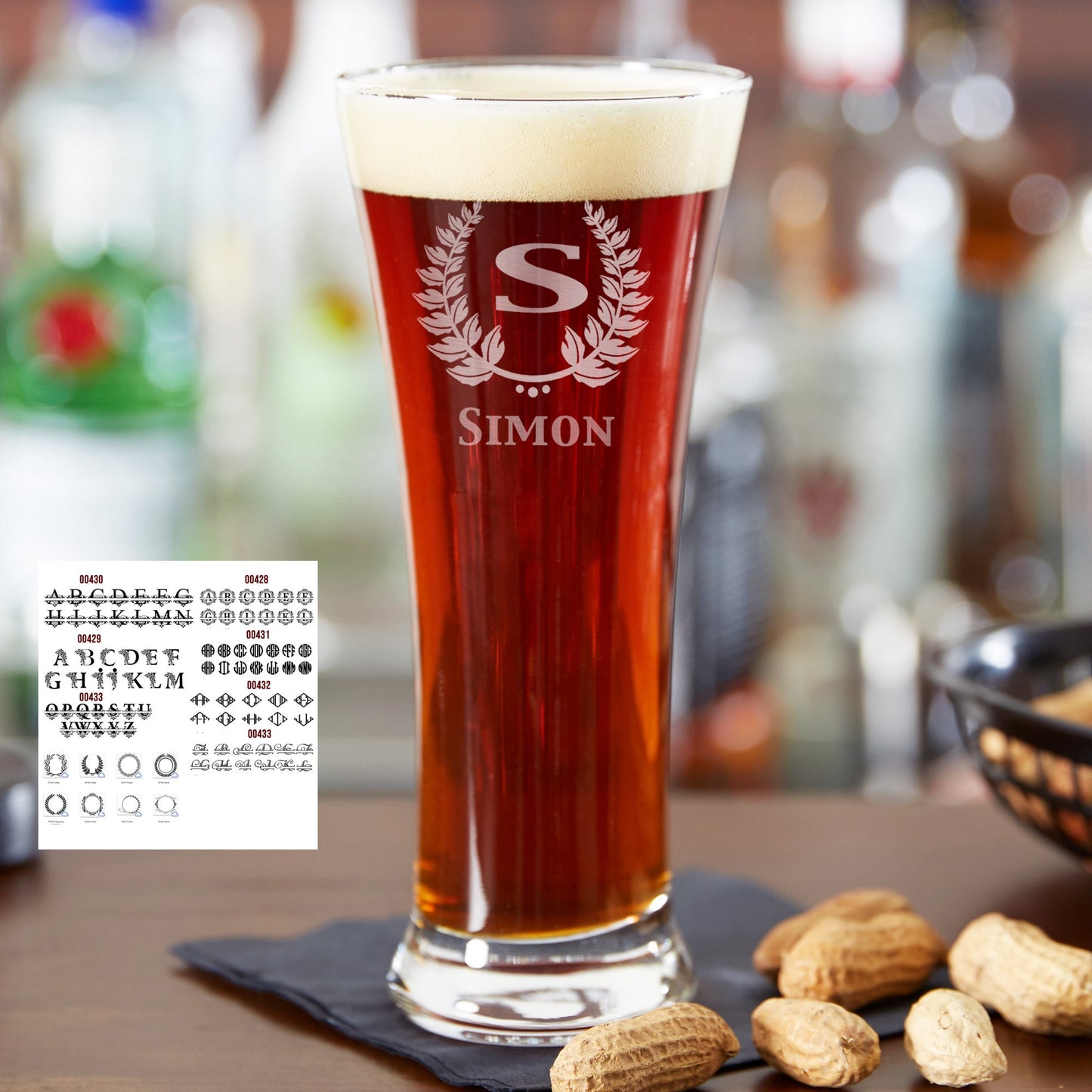 A clear personalized pilsner beer glass, 12 oz, laser engraved with a custom initial and name on a wooden surface.