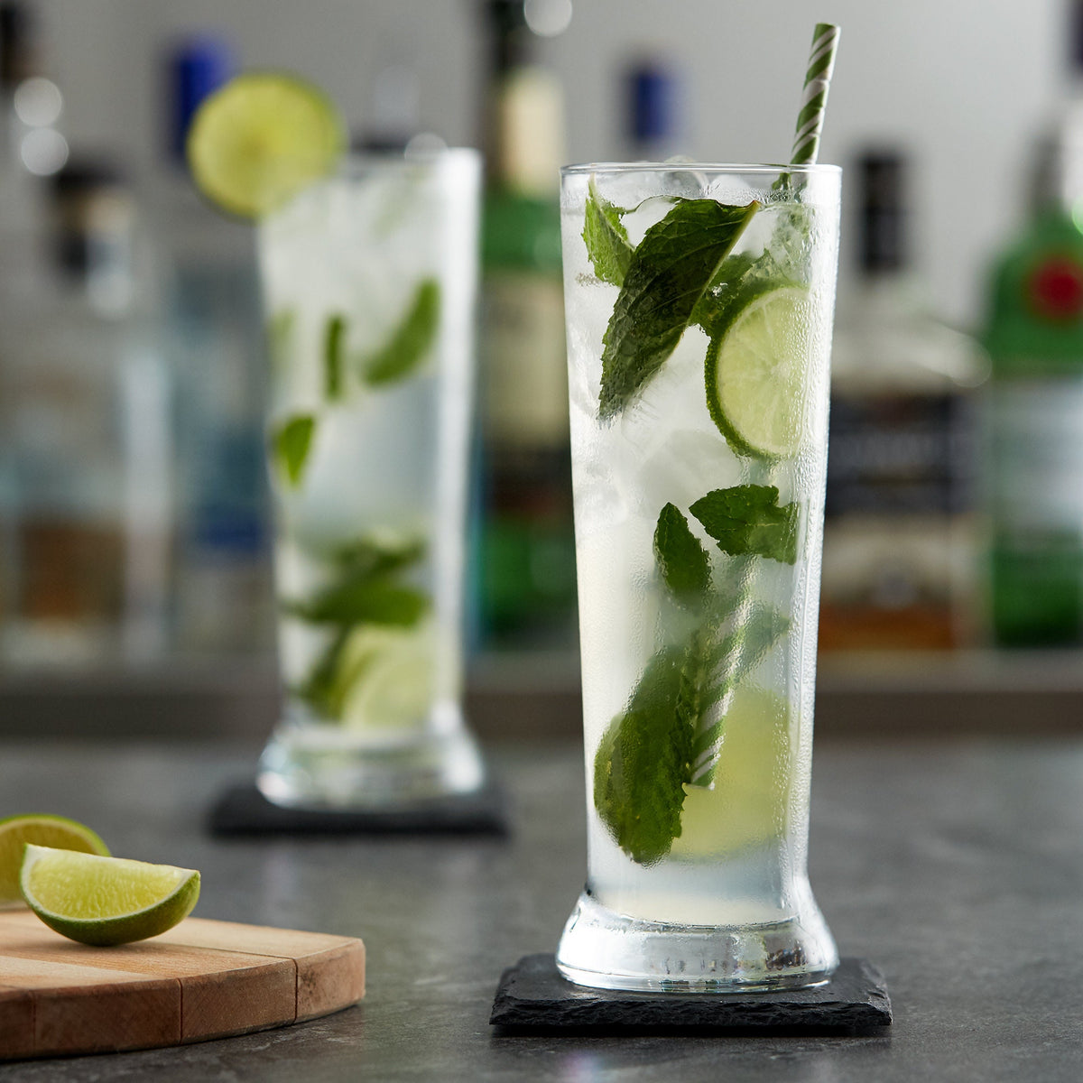 Tall pilsner cooler glass used for a mojito cocktail with lime and mint