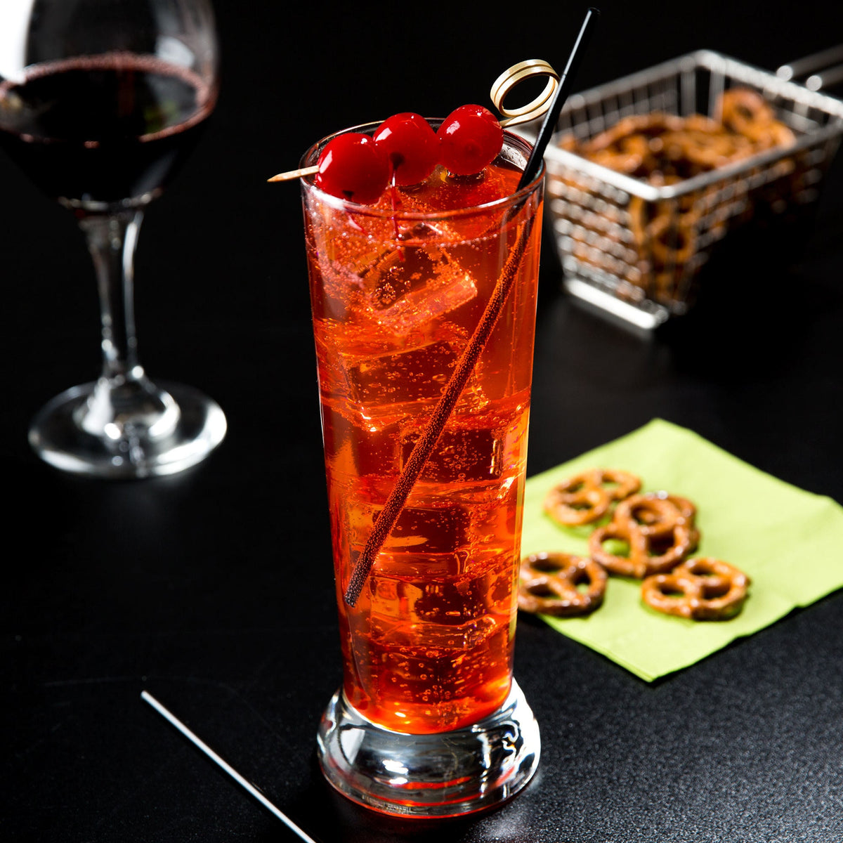 16.25 oz pilsner cooler glass with red cocktail and cherries, shown as a highball and cocktail glass