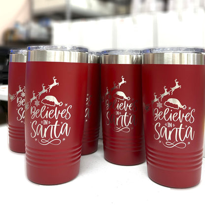 Close-up of 'Believes in Santa' laser-engraved text and charming reindeer design on a red Christmas tumbler.