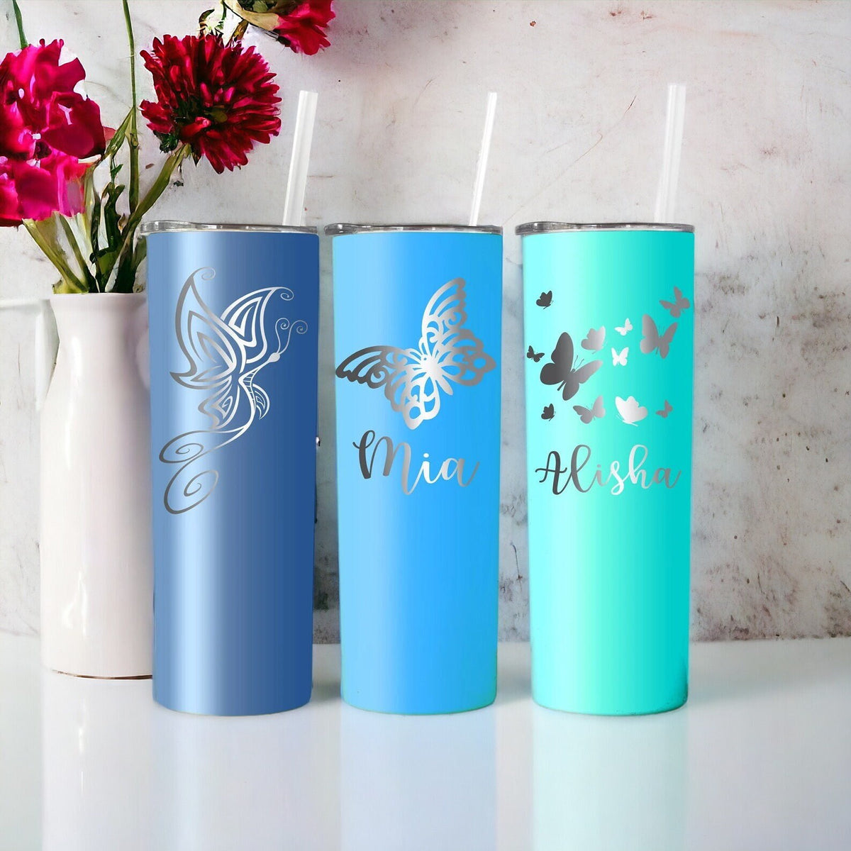 Hand holding a personalized butterfly tumbler, showcasing its ergonomic design and laser engraving.