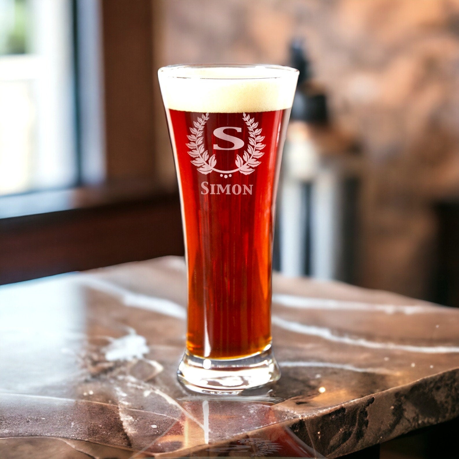 A 12 oz personalized pilsner beer glass featuring a corporate logo engraving, suitable for restaurant branding.
