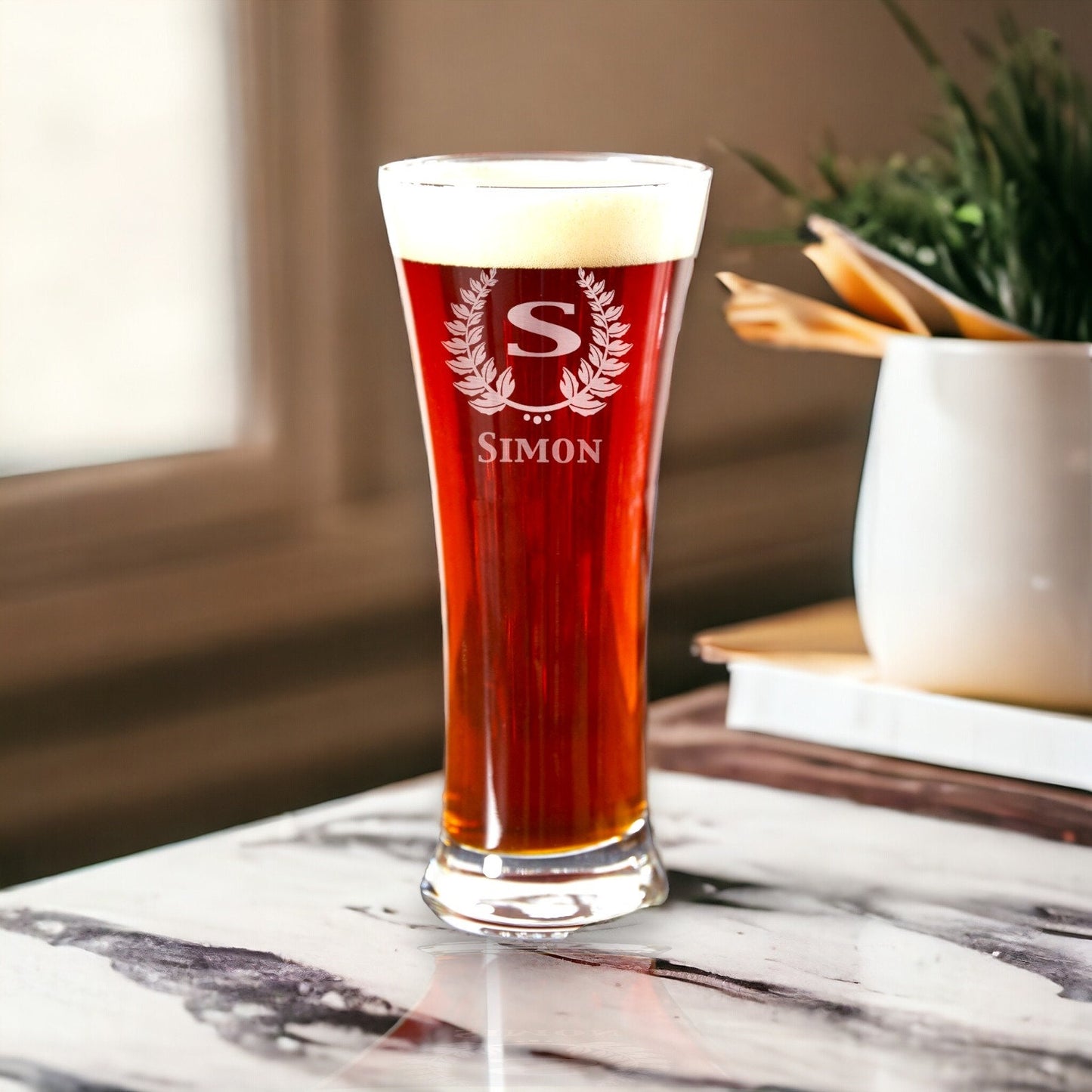 A lineup of monogrammed pilsner glasses, 12 oz each, ideal as groomsmen beer gifts on a light countertop.