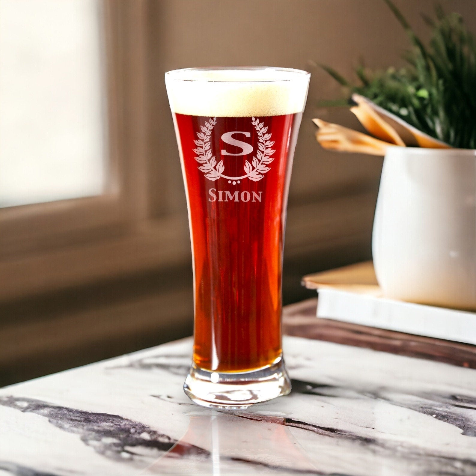 A lineup of monogrammed pilsner glasses, 12 oz each, ideal as groomsmen beer gifts on a light countertop.