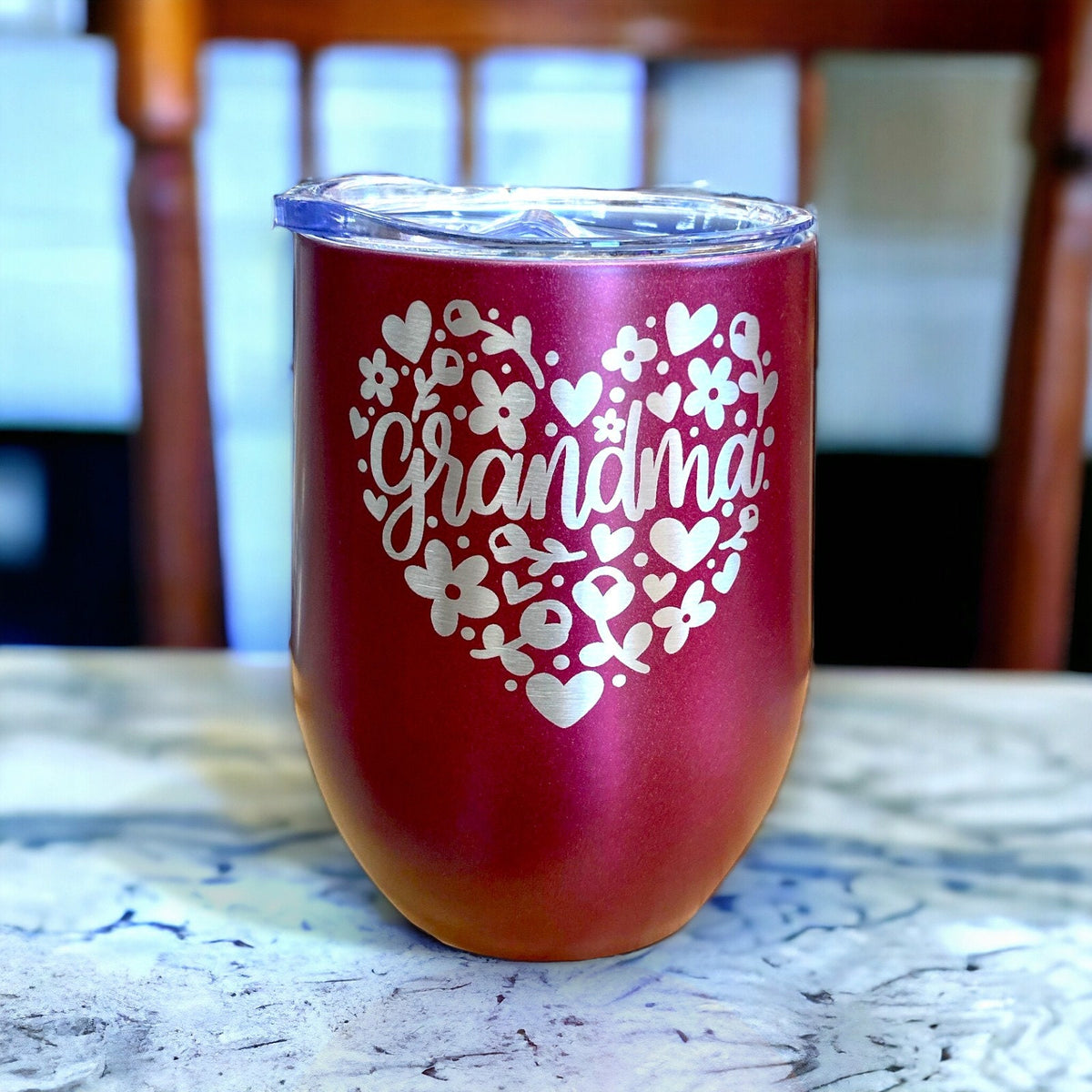 Angled view of an engraved pink grandma tumbler, highlighting its smooth matte finish and sturdy base.