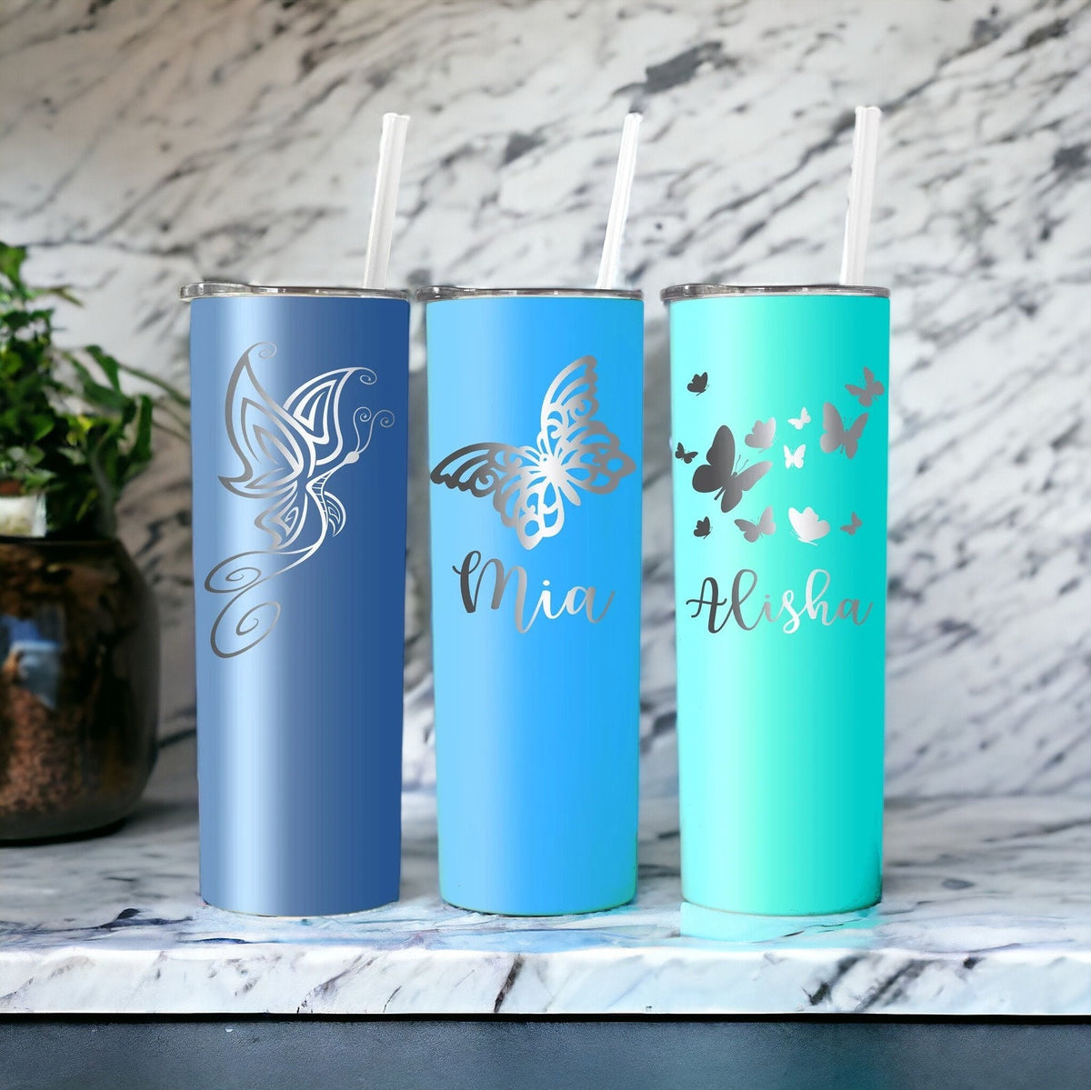 Detailed shot of the custom laser engraved butterfly design on a 20 oz stainless steel tumbler.
