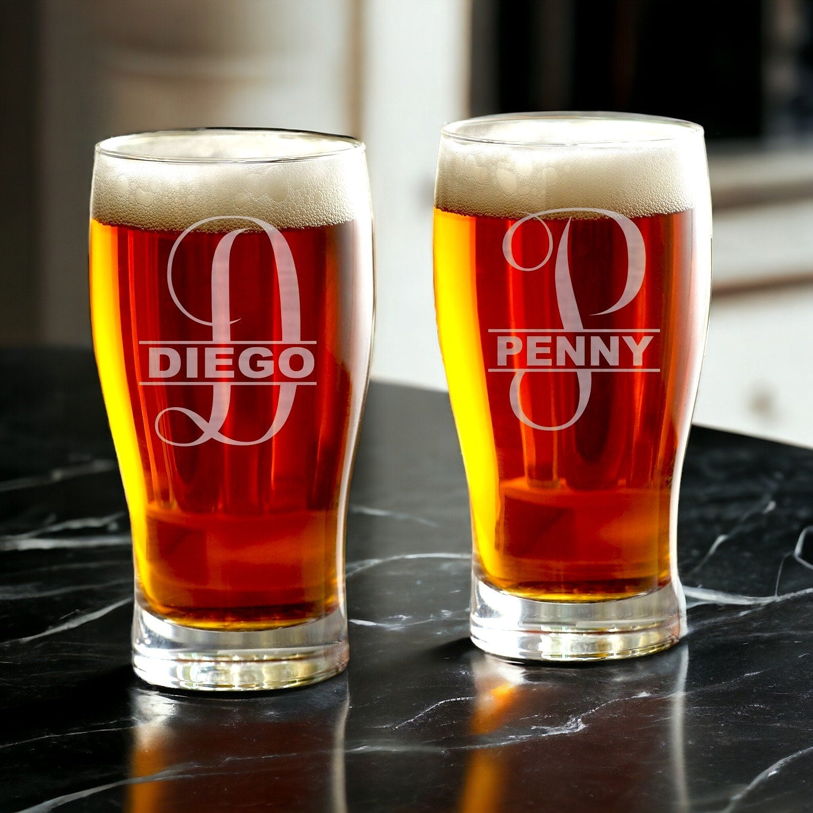 A collection of custom etched pint glasses with various personalized designs, ready for gifting or use.
