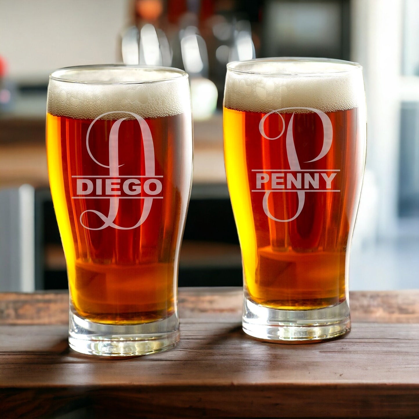Monogrammed beer glass featuring an intricate etched design, photographed against a softly lit background.