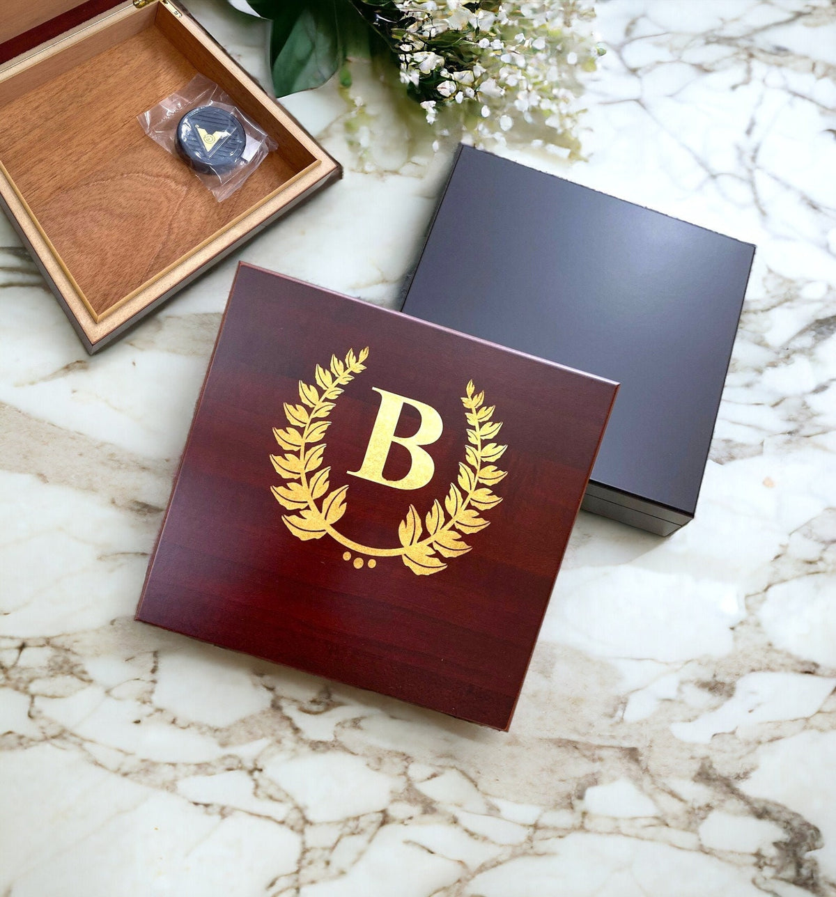 Personalized desktop humidor showing a custom name engraved in gold on black wood finish.