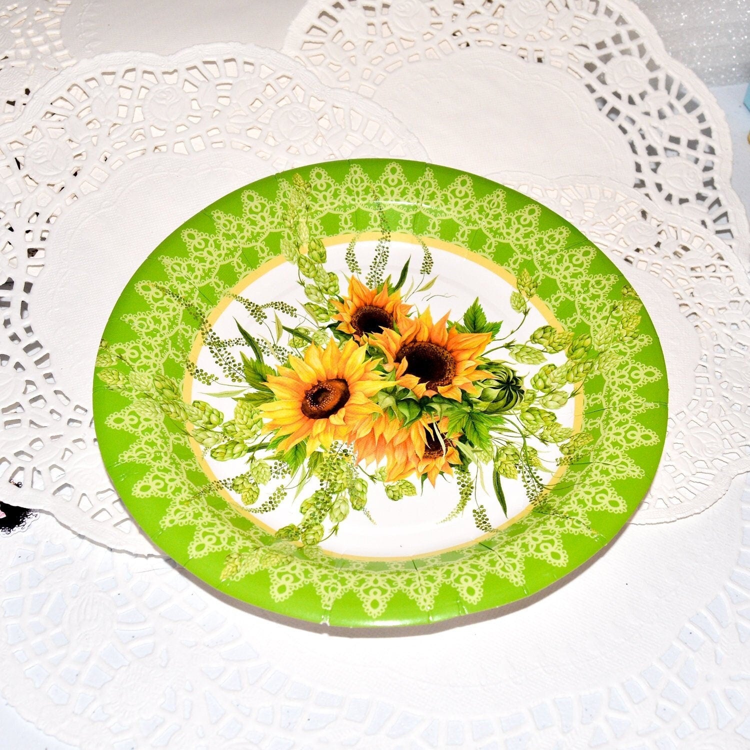 Arrangement of disposable sunflower paper plates showing the detailed floral design and sturdy material.