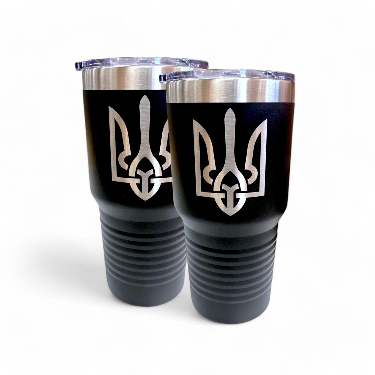 Pair of black 30 oz travel mugs with silver Ukrainian Tryzub emblems and clear lids on a white background.
