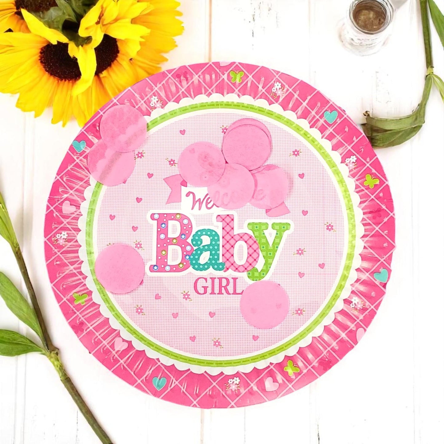 Close-up of a single 7-inch 'Welcome Baby Girl' plate with a delicate pink floral border and elegant script.