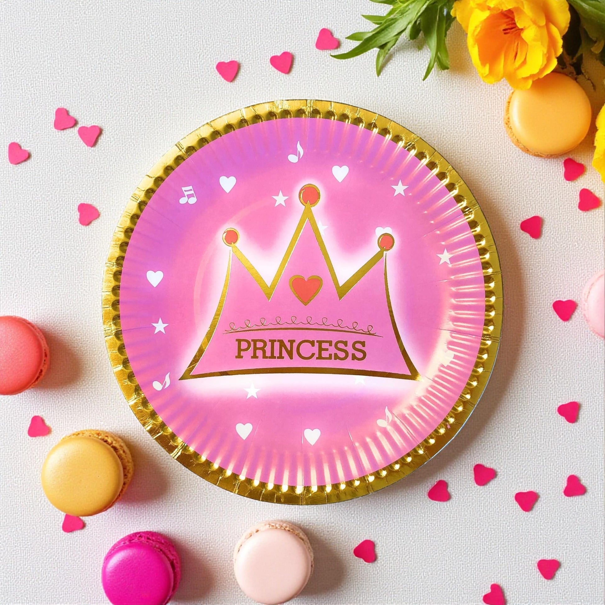 Arrangement of several pink and gold crown dessert plates on a pastel background for a princess party.