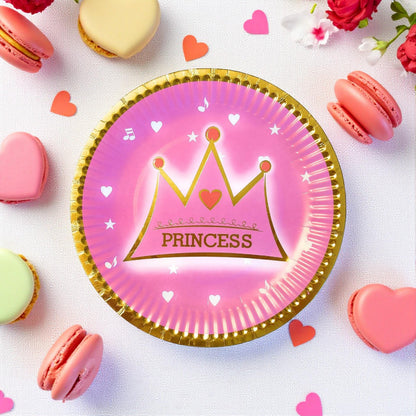 Stack of pink princess party paper dessert plates with gold crown design, ready for a celebration.