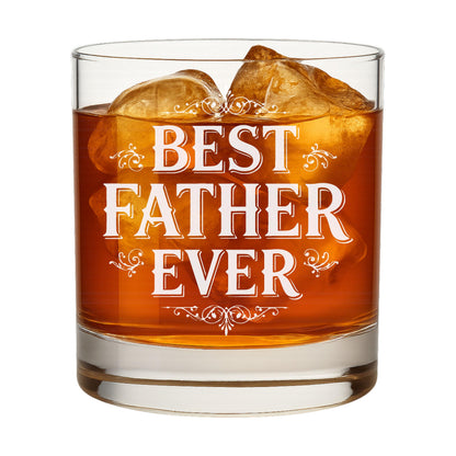 Whiskey glass with "Best Father Ever" engraving, shown with a bottle of bourbon in a home bar setting.