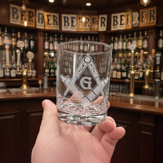 Close-up of a laser engraved rocks glass, showcasing the detailed Freemason Square and Compass design.