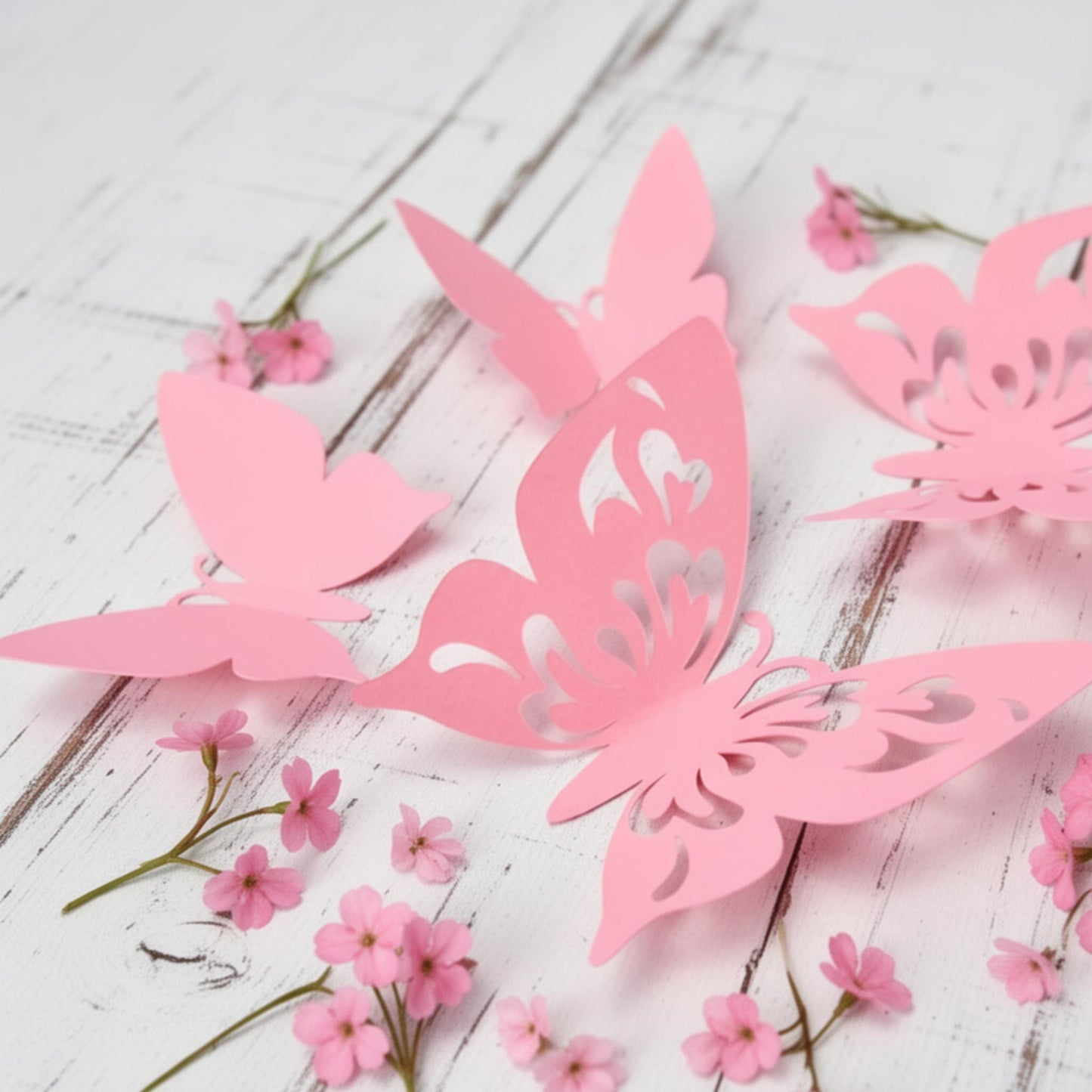 Set of 12 pink 3D cardstock butterflies, fanned out to show varying sizes and delicate details for wall decor.
