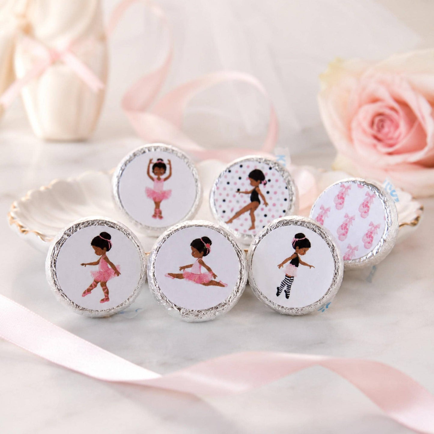 Close-up of a pink tutu ballerina sticker applied to a chocolate kiss candy, ideal for party treats.