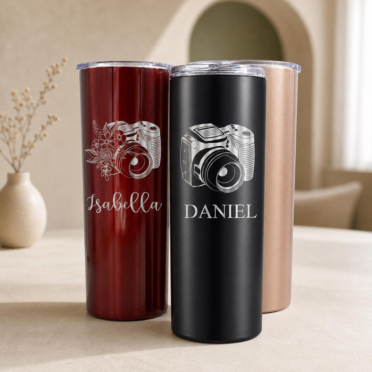 A white photographer tumbler cup with a laser-engraved camera lens design, 20 oz capacity, on a white background.