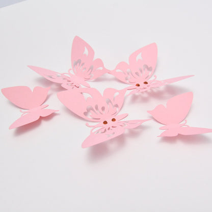 Arrangement of multiple pink paper butterflies of different sizes, creating an elegant and ethereal wall decoration for a child's nursery or bedroom.