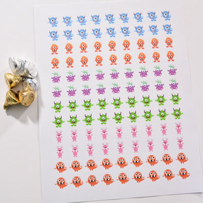 Group of foil kisses decorated with monster labels on the bottom, perfect for baby shower favors.