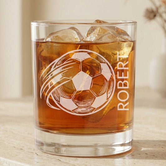 Glass of iced tea with a soccer ball design and 'ROBERT' text, against a festive background with lights and presents.