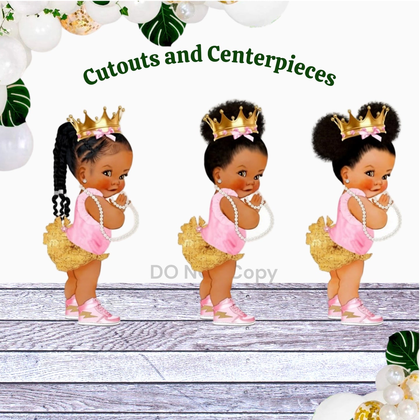 Three African American princess centerpieces with pink and gold accents, standing on a white surface.